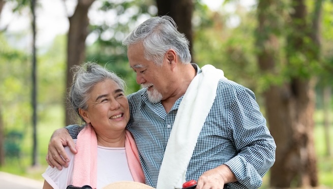 Senior couple embracing and holding hands together in the park