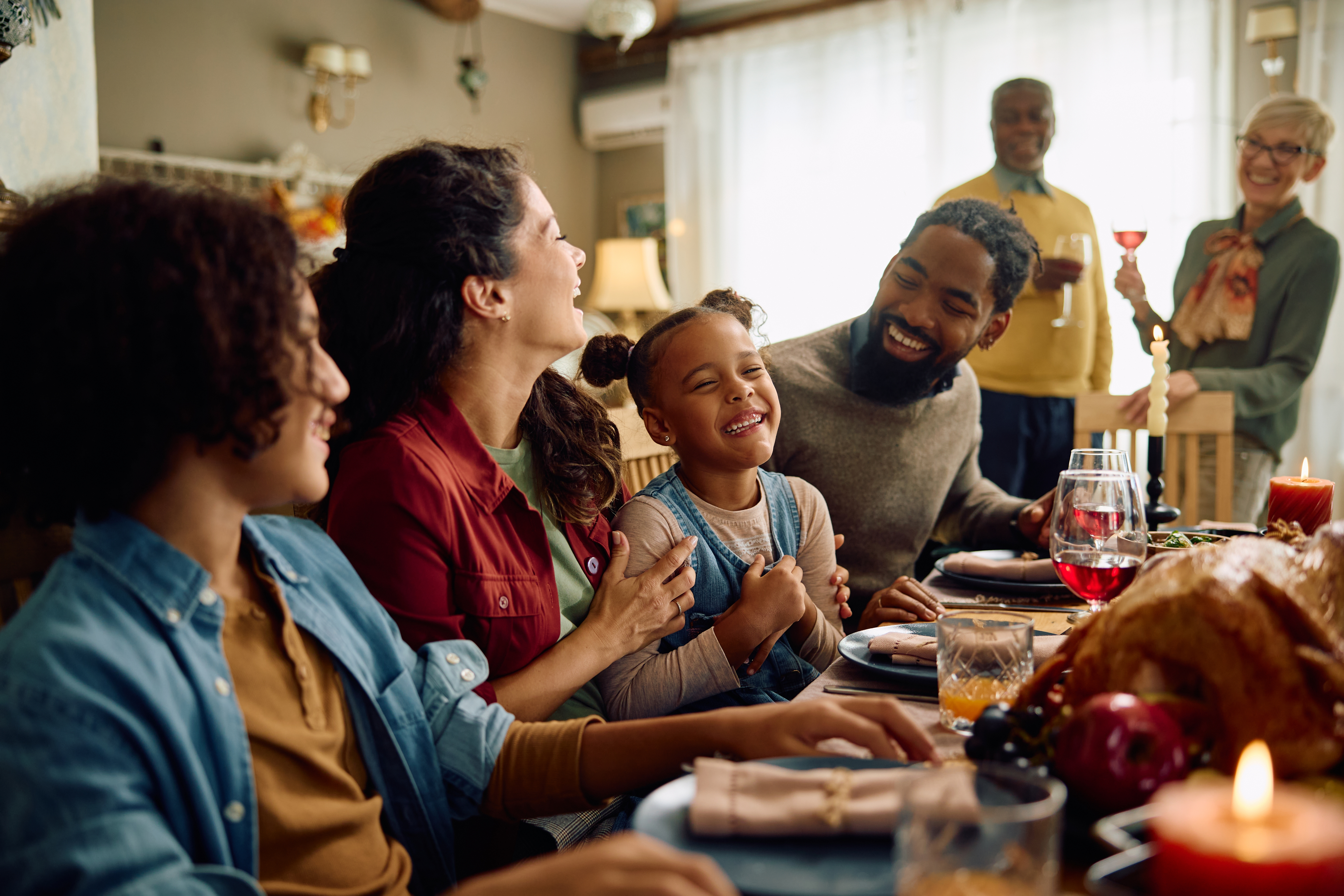 Smiling family at holiday dinner table.
